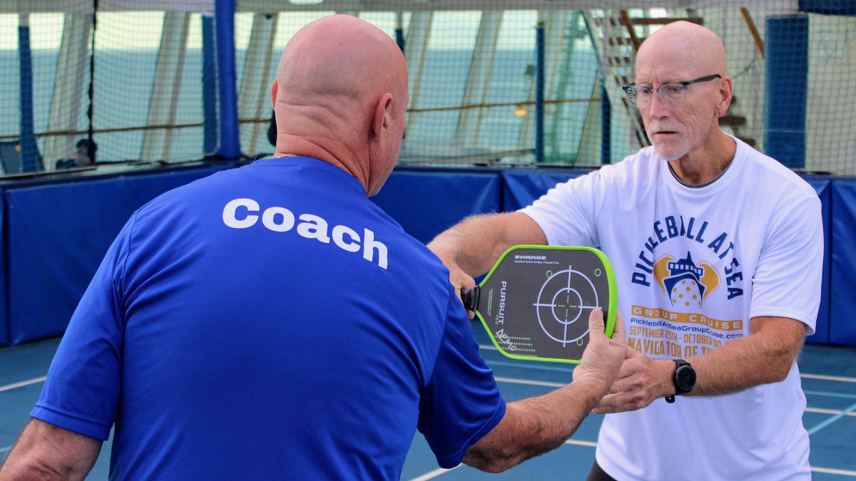 Pickleball Pro giving a Guest a one-on-one lesson on the onboard court during a Pickleball At Sea Group Cruise.