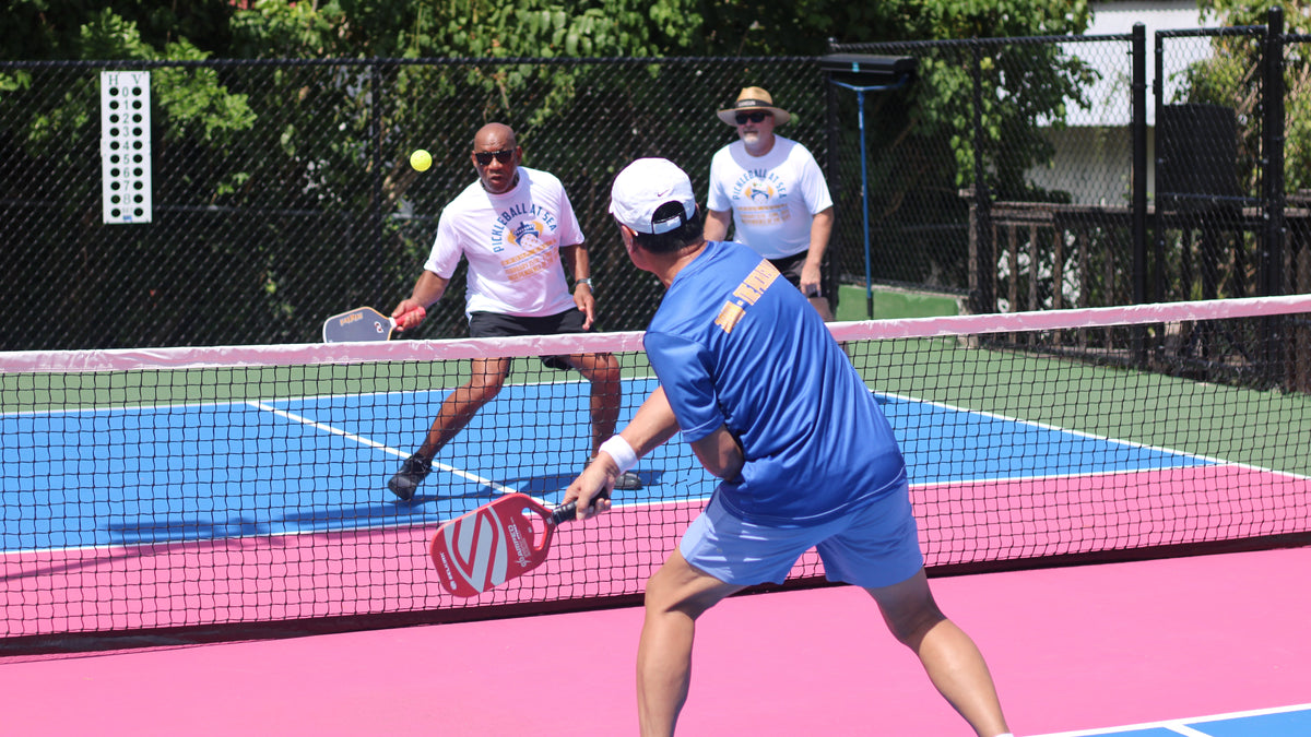 Pickleball At Sea Group Cruise Guests playing doubles on an outdoor court ashore during their Pickleball vacation.